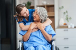 Caregiver and Elderly Patient in a Wheelchair Hugging