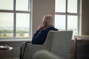 Lonely Elderly Man Sitting in a Chair at Home