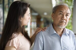 Daughter Putting Hand on Shoulder of Her Father with Dementia