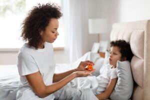 Mother Giving Child Medication in Bed